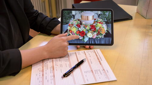 Mitarbeiterin bei Flunkert Bestattungen zeigt Urnenschmuck auf einem Tablet